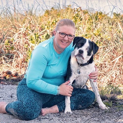 Rebecca Stevens sitting with her black and white dog